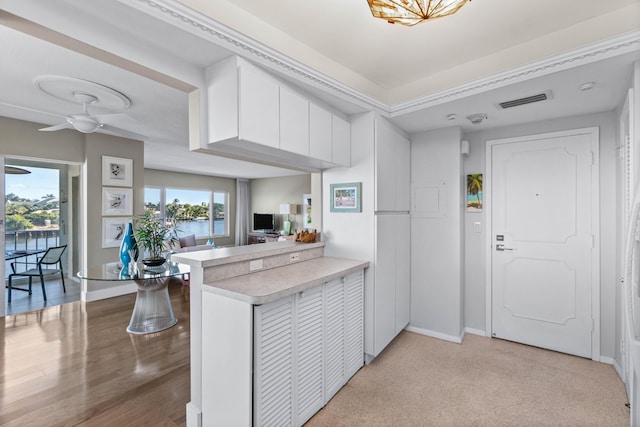 kitchen featuring white cabinets, ceiling fan, and kitchen peninsula