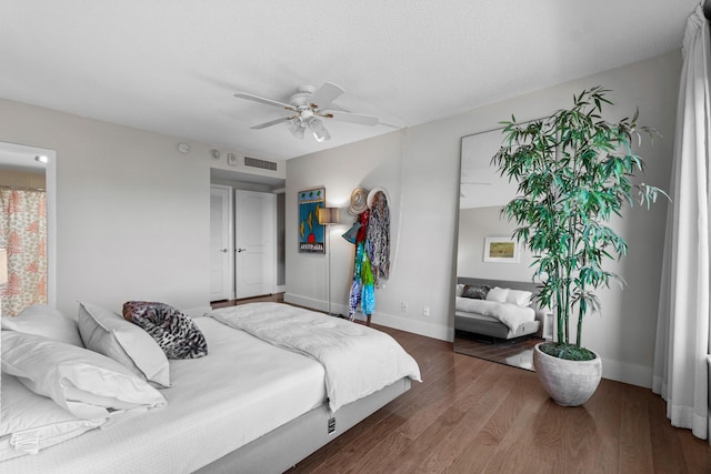 bedroom with ceiling fan, dark hardwood / wood-style floors, and a textured ceiling