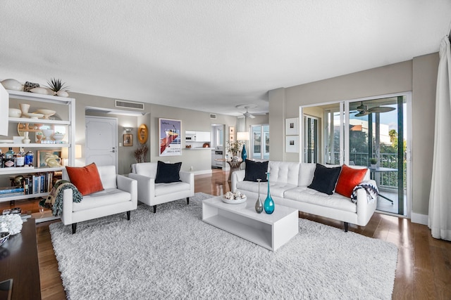 living room featuring a textured ceiling, dark hardwood / wood-style flooring, and ceiling fan