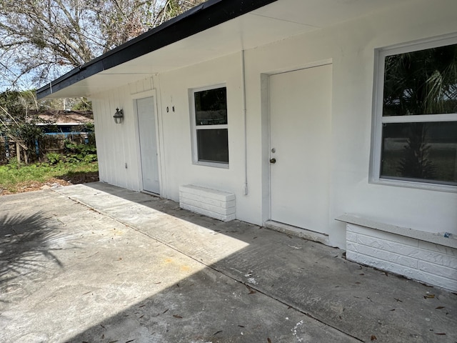 entrance to property featuring a patio area and fence