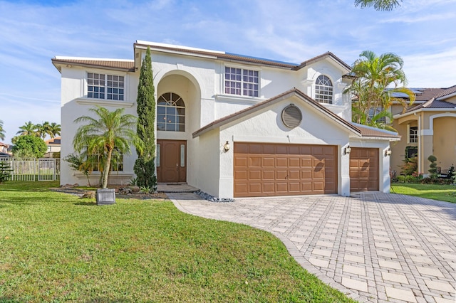 mediterranean / spanish-style house featuring a garage and a front yard