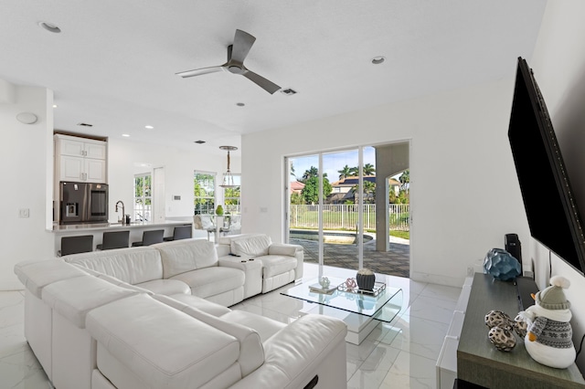 living room featuring ceiling fan and sink