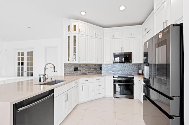 kitchen featuring sink, dishwasher, refrigerator, white cabinets, and decorative backsplash