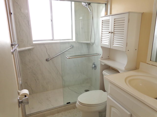 bathroom featuring vanity, toilet, and a shower with door