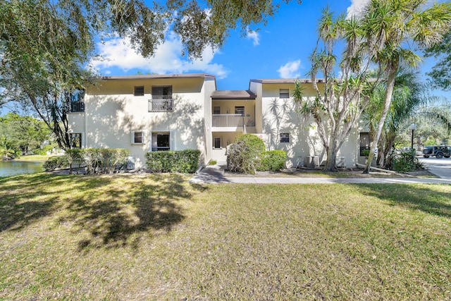 view of front of home with a front yard and a balcony