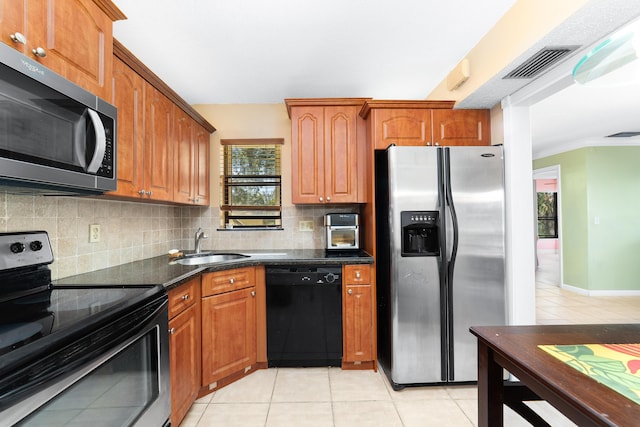 kitchen with sink, crown molding, decorative backsplash, light tile patterned floors, and black appliances