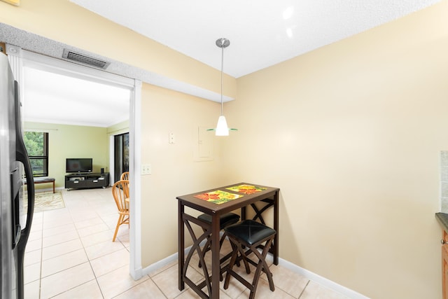 dining space with light tile patterned floors and ornamental molding