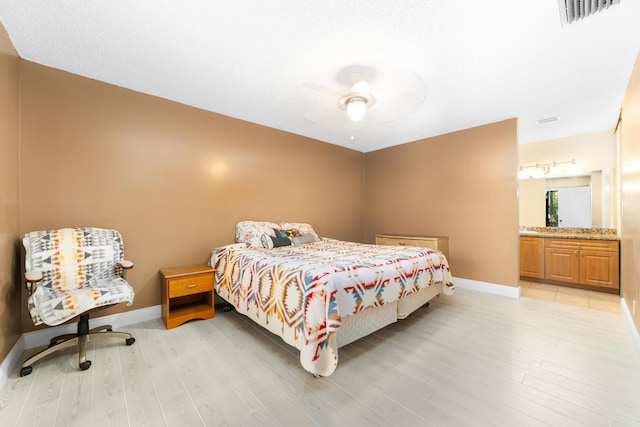 bedroom with ceiling fan, light hardwood / wood-style floors, and ensuite bathroom