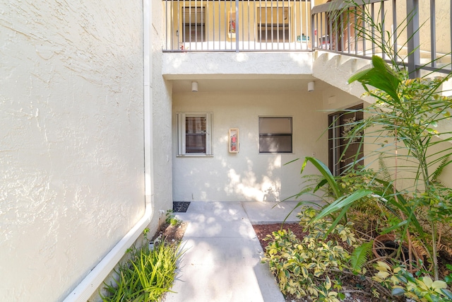 view of exterior entry featuring a balcony