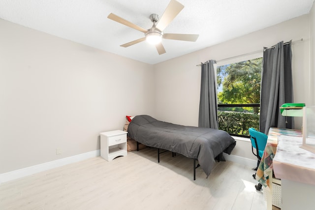 bedroom with light hardwood / wood-style floors and ceiling fan