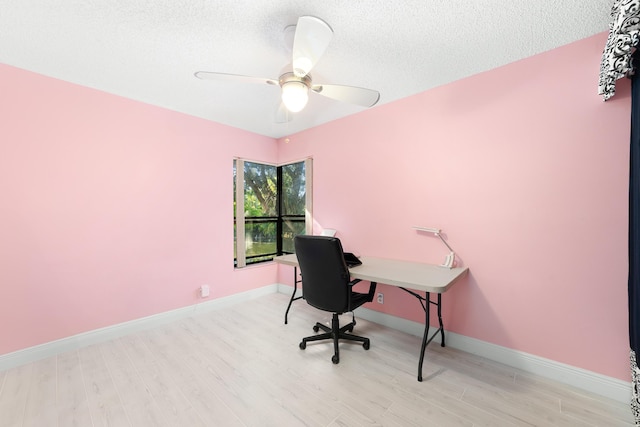 office area with ceiling fan, light hardwood / wood-style floors, and a textured ceiling