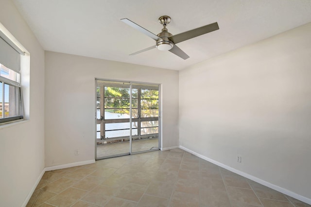 tiled spare room featuring ceiling fan