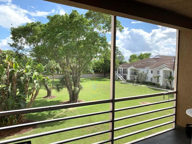 view of grassy yard with a residential view and a balcony