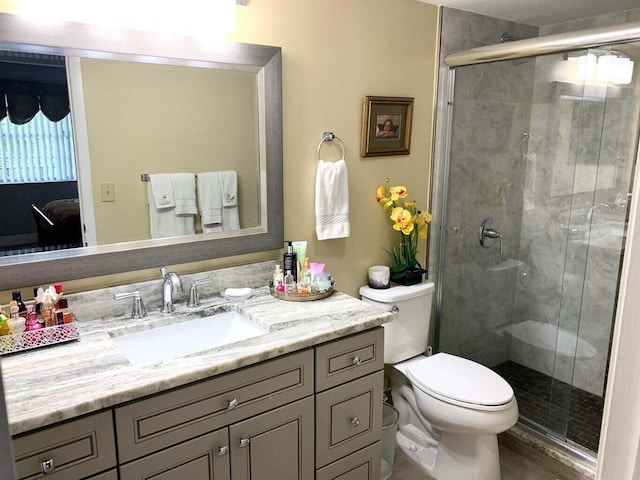 bathroom with vanity, toilet, and a shower with door