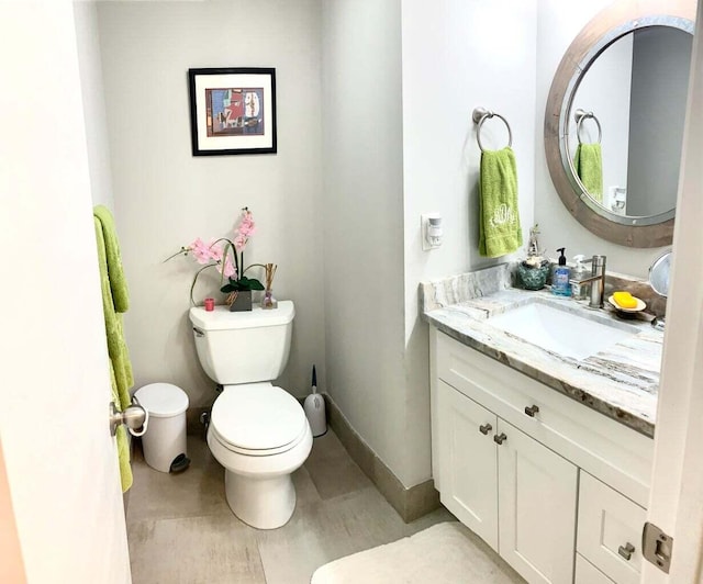 bathroom with toilet, vanity, and hardwood / wood-style flooring