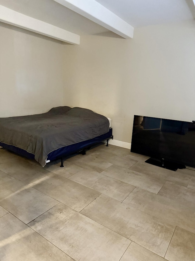 bedroom with beamed ceiling and baseboards