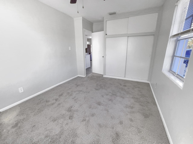 unfurnished bedroom with light carpet, a closet, and ceiling fan