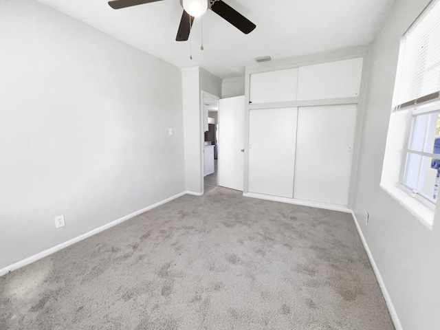 unfurnished bedroom with ceiling fan, light colored carpet, and a closet