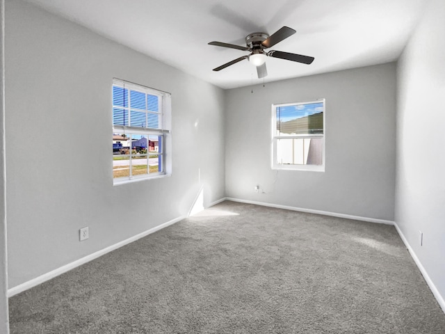 carpeted spare room featuring ceiling fan