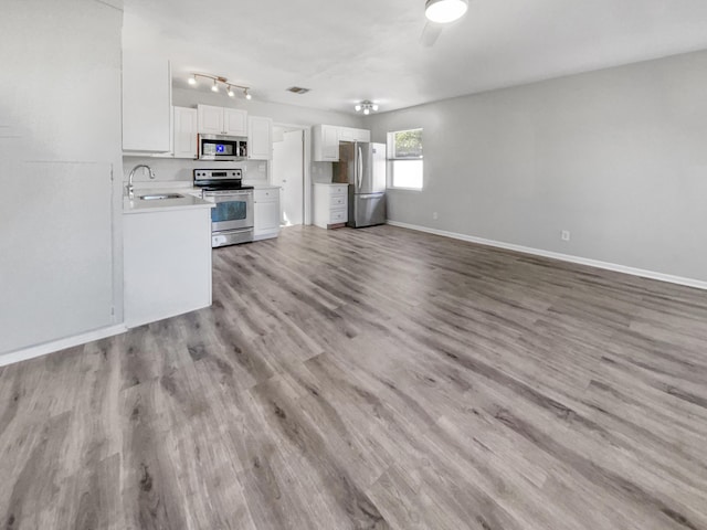 kitchen featuring white cabinets, stainless steel appliances, light hardwood / wood-style flooring, and sink