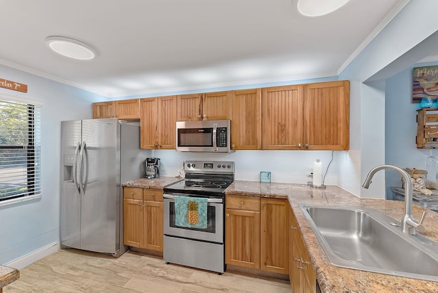 kitchen featuring ornamental molding, sink, stainless steel appliances, and light wood-type flooring