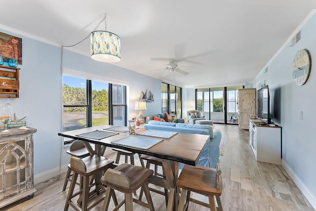 dining space featuring ceiling fan, ornamental molding, and light wood-type flooring