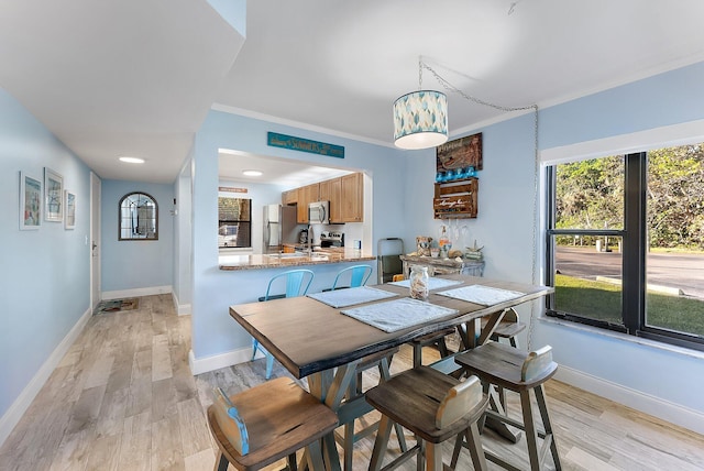 dining room featuring light hardwood / wood-style floors and ornamental molding