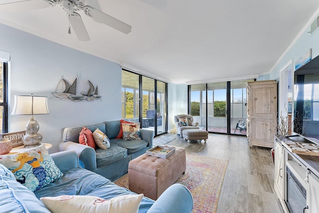 living room with a wall of windows, ornamental molding, french doors, and light hardwood / wood-style flooring