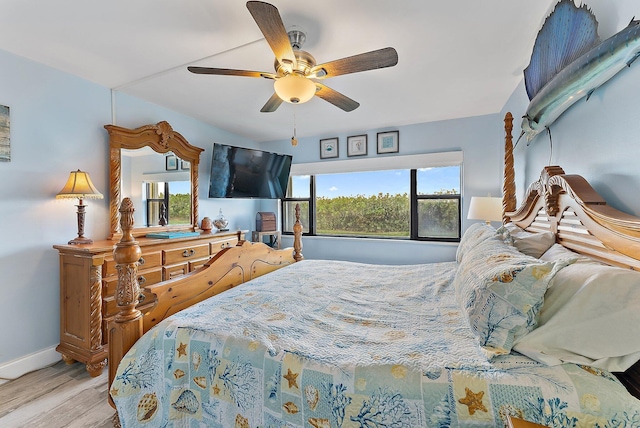 bedroom with multiple windows, ceiling fan, and light hardwood / wood-style floors