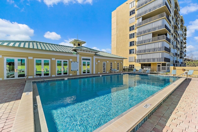 view of swimming pool with french doors and a patio