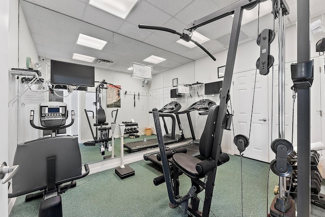 exercise room with carpet flooring and a drop ceiling