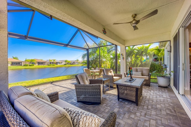 view of patio with ceiling fan, an outdoor hangout area, glass enclosure, and a water view