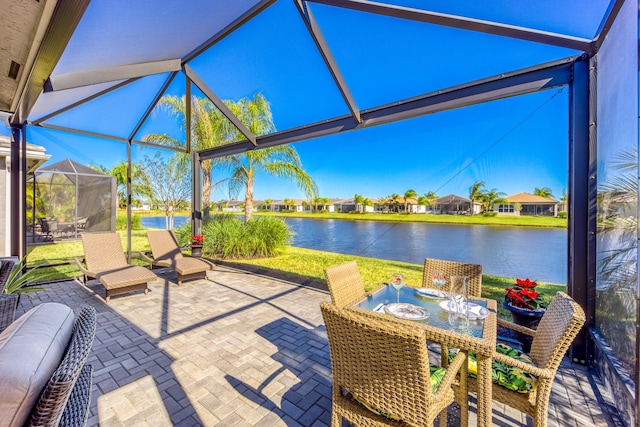 view of patio featuring a water view and glass enclosure
