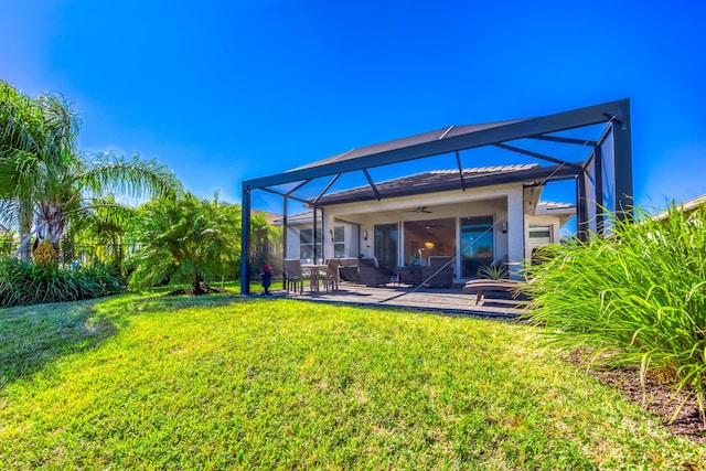 rear view of house featuring a patio, a lanai, a yard, and ceiling fan