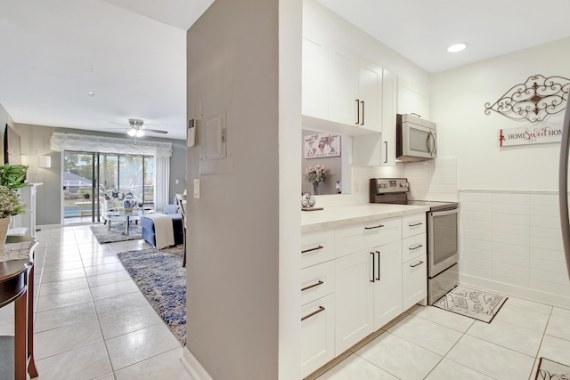 kitchen featuring light countertops, white cabinetry, light tile patterned floors, appliances with stainless steel finishes, and ceiling fan