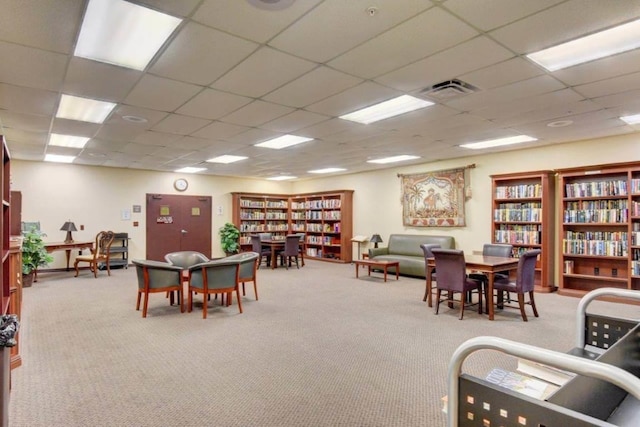 rec room featuring a drop ceiling and light carpet