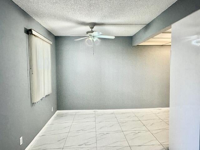 spare room with beam ceiling, ceiling fan, and a textured ceiling