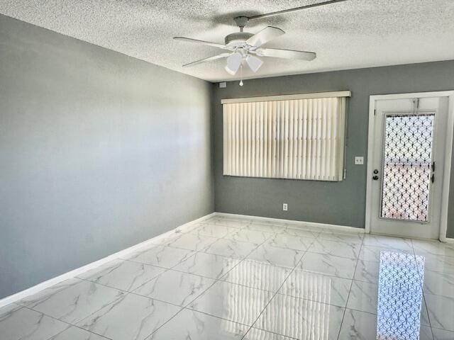 unfurnished room with a textured ceiling and ceiling fan