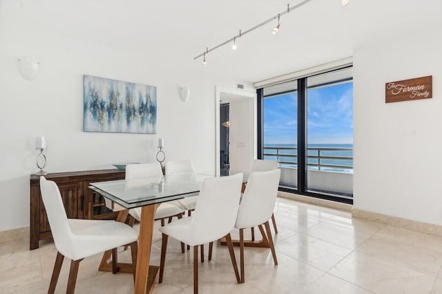 dining space with floor to ceiling windows and a water view