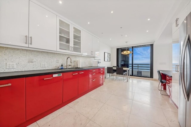 kitchen featuring decorative backsplash, stainless steel fridge, white cabinetry, and sink