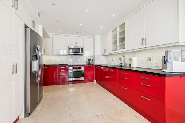 kitchen featuring white cabinets, decorative backsplash, sink, and stainless steel appliances