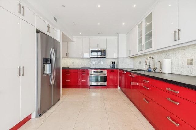 kitchen featuring white cabinets, appliances with stainless steel finishes, and backsplash