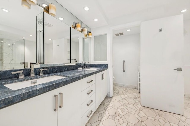 bathroom featuring tile patterned floors, vanity, toilet, and a shower with shower door