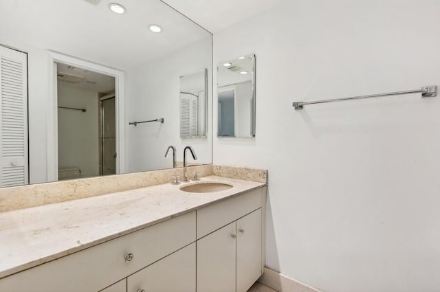 bathroom with vanity, a shower with shower door, and toilet