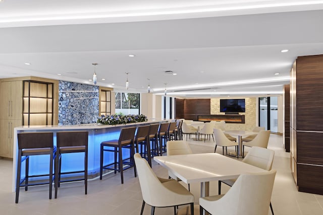 dining space with light tile patterned floors and a fireplace