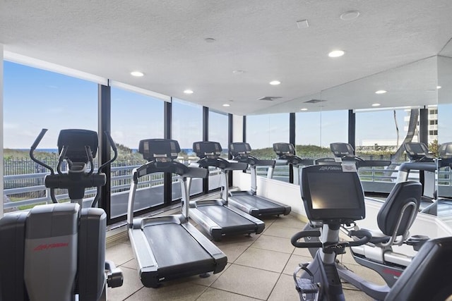 gym with a textured ceiling and a wall of windows