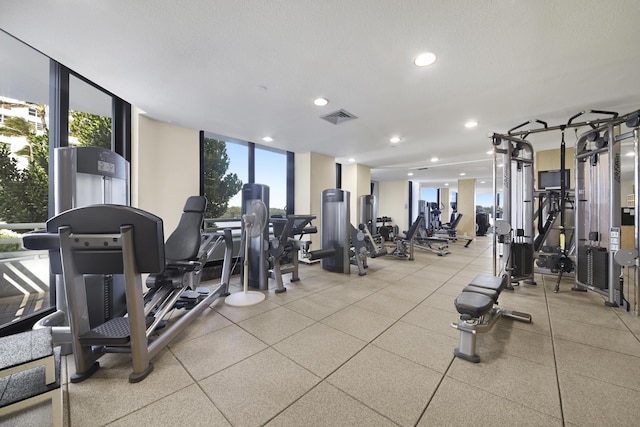 exercise room featuring floor to ceiling windows and a textured ceiling