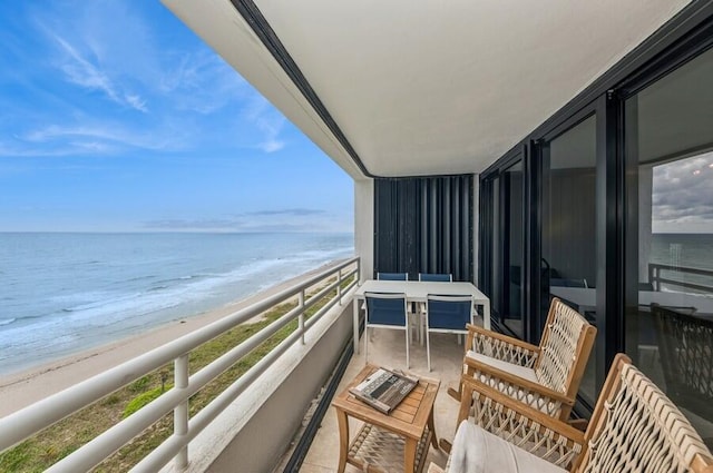 balcony featuring a water view and a view of the beach