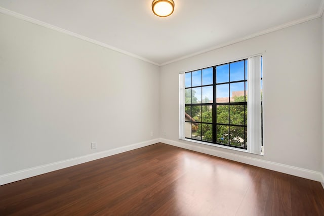 empty room with dark hardwood / wood-style flooring and crown molding