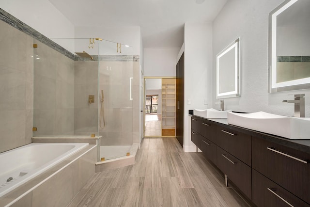 bathroom featuring vanity, hardwood / wood-style floors, and plus walk in shower